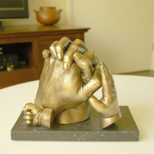 handen samenstelling op gepolijste sokkel met geel bronzen beschildering