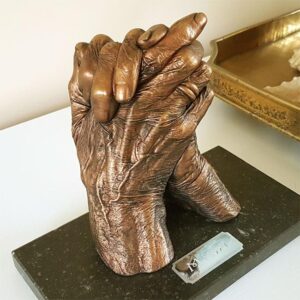 Twee handen van Mimi, 90 jaren. Rood bronzen beschildering met patina